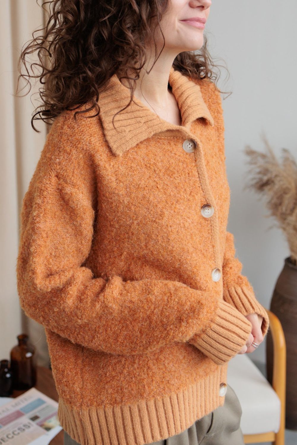 Textured bouclé collar cardigan in tangerine with button front and ribbed cuffs.