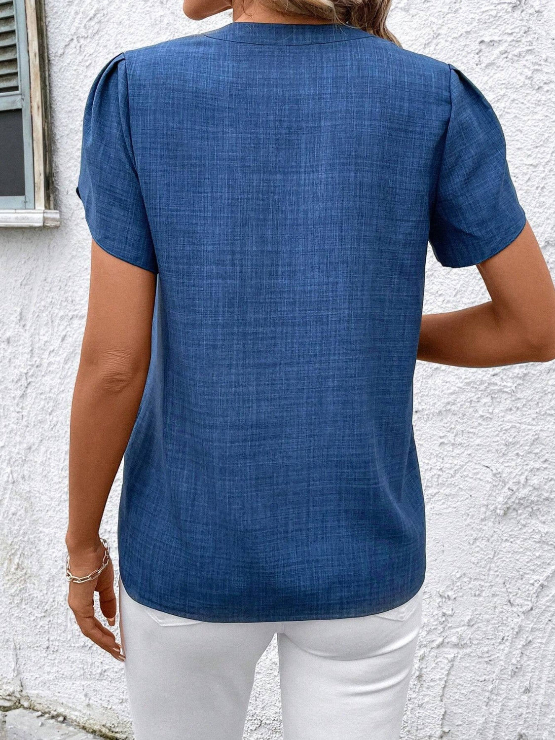 Blue short sleeve blouse with textured fabric and puffed sleeves.