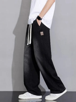 Relaxed vintage wash black wide-leg jeans with drawstring and patch detail.