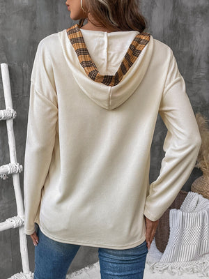 Cream waffle knit henley hooded top with plaid lining detail.
