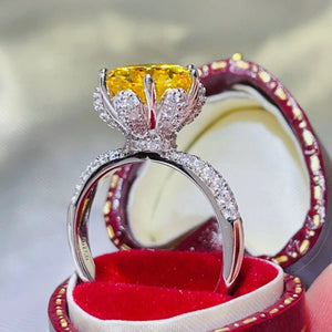 Yellow moissanite solitaire ring with diamond band in a jewelry box