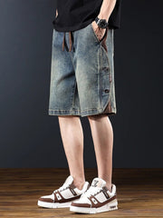 Men's medium wash wide leg denim shorts with button detail and drawstring waist.