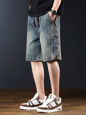 Men's medium wash wide leg denim shorts with button detail and drawstring waist.