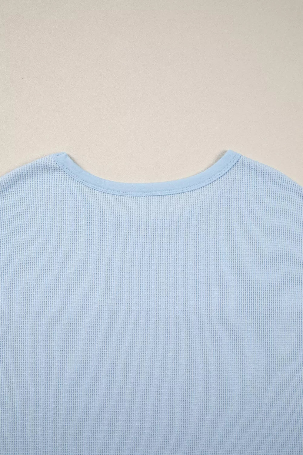 Light blue waffle knit t-shirt with crew neck and polyester fabric.