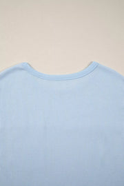 Light blue waffle knit t-shirt with crew neck and polyester fabric.