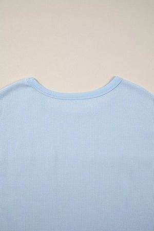 Light blue waffle knit t-shirt with crew neck and polyester fabric.