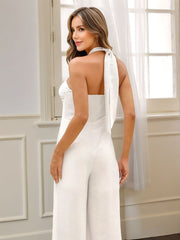 White halter jumpsuit with wide legs and a ring detail on the neckline.