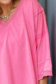 Pink V-neck tee with raw-edge seam details on the sleeves and neckline.