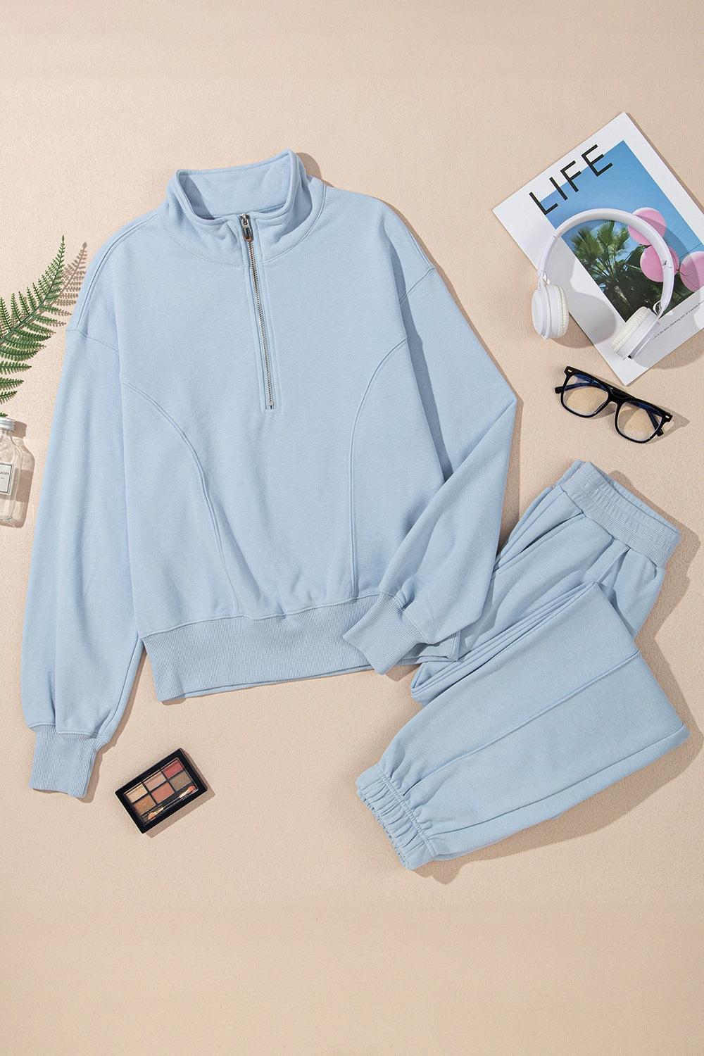 Light blue quarter-zip sweatshirt and jogger set with ribbed cuffs and waistband.