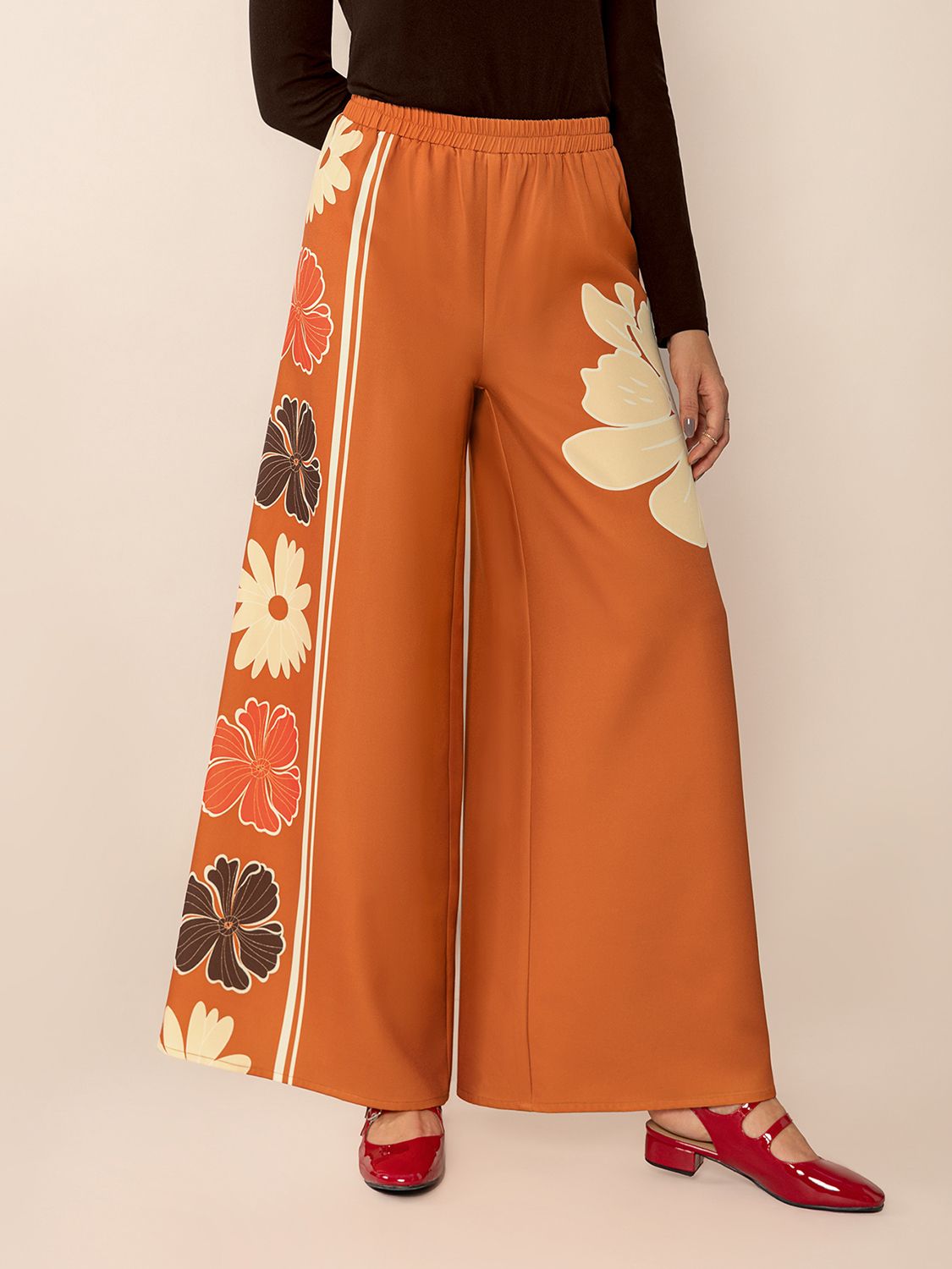 Seventies floral palazzo trousers in tangerine with side stripe and large floral print.