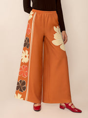 Seventies floral palazzo trousers in tangerine with side stripe and large floral print.