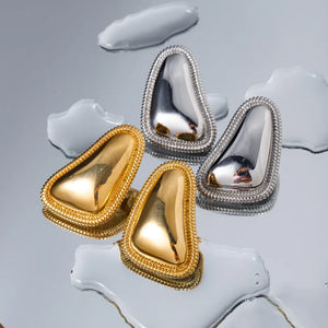 Sculpted gold and silver vermeil earrings with textured trim.