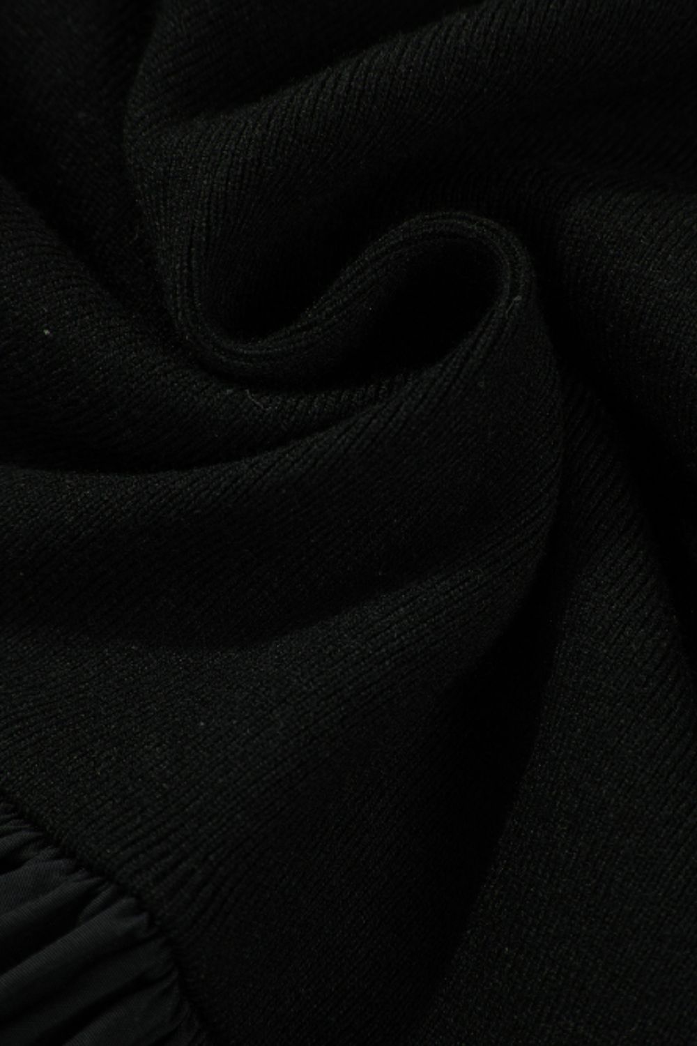 Black ribbed bodice peplum top with a ruffled hem detail.
