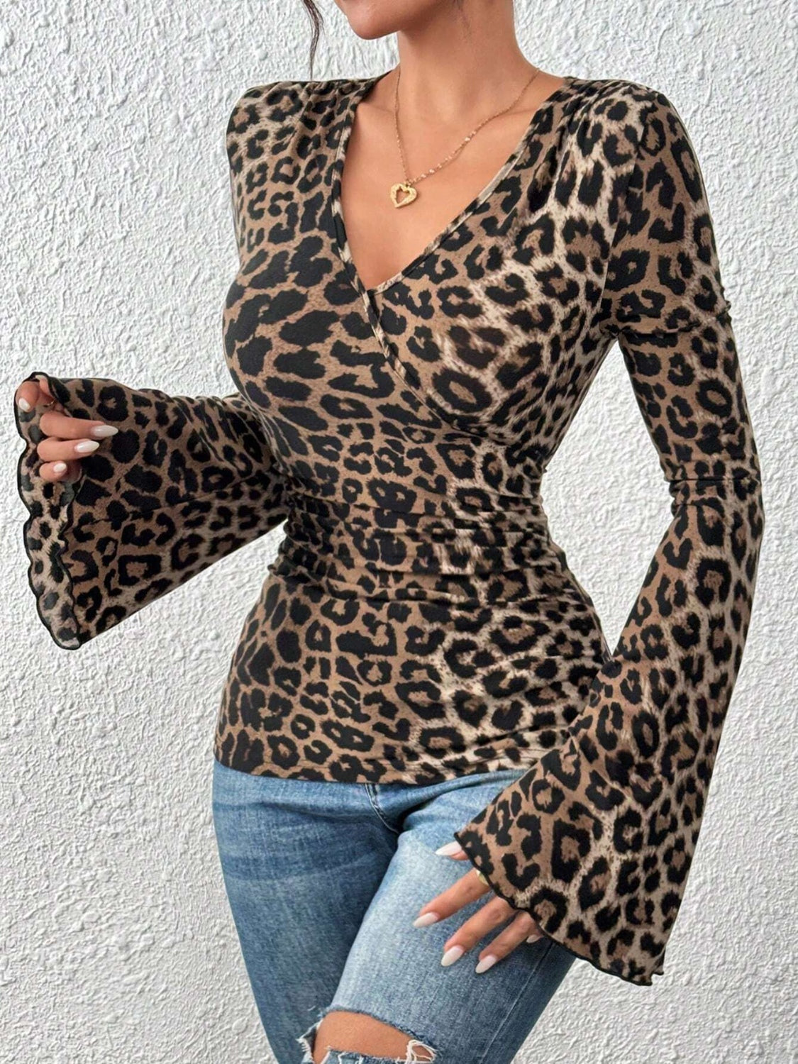 Leopard print wrap blouse with flared sleeves and a deep V-neck.