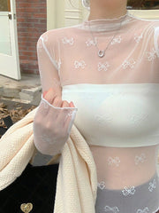 Sheer white mesh shirt with all-over bow print and lettuce trim cuffs.