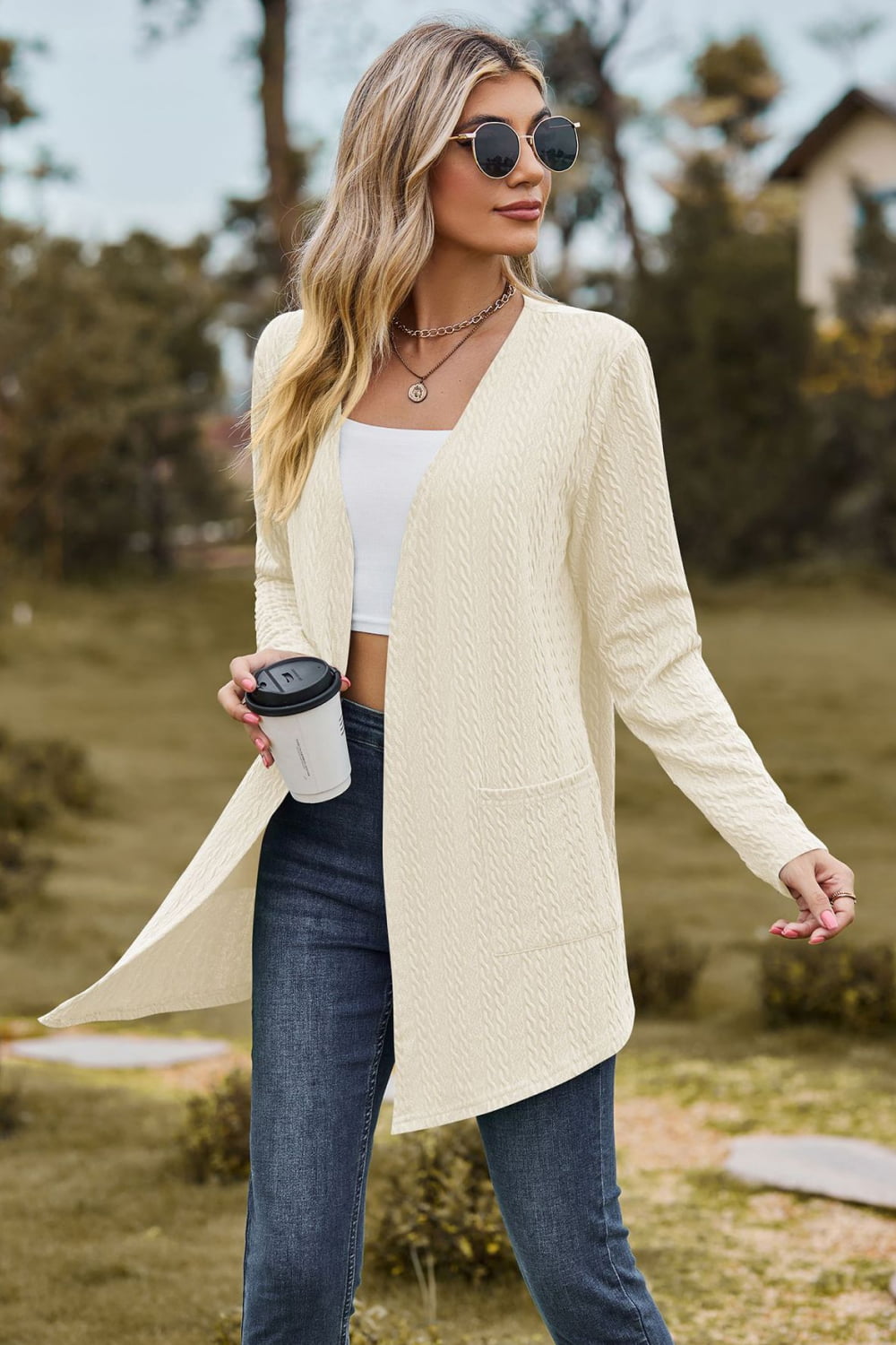 Cream textured open-front cardigan with pockets and long sleeves.