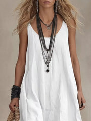 White scoop neck maxi dress with layered necklaces and bracelets.