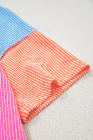 Vibrant ribbed t-shirt with color block stripes in pink, orange, and blue.