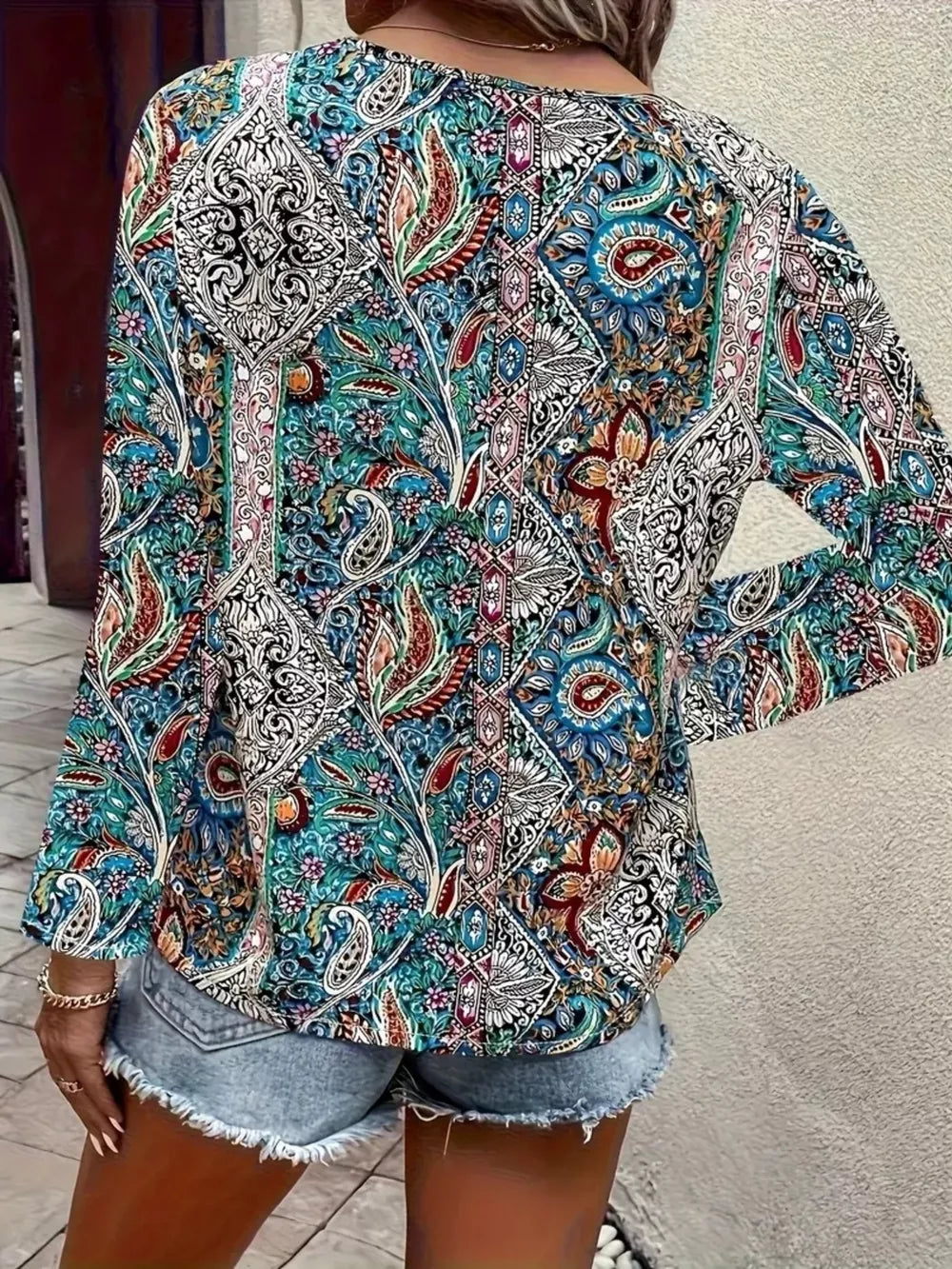 Bohemian paisley v-neck shirt in multicolor with long sleeves, styled with denim shorts.
