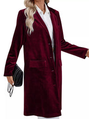Burgundy velvet longline trench coat with lapel collar and buttoned front.
