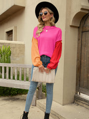 Colorblock drop shoulder knit sweater with pink, orange, and red sleeves.