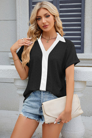 Black perforated polo top with white V-neck panel and short sleeves.