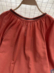 Apricot tie neck blouse with billowy sleeves and embroidered detail.