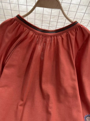 Apricot tie neck blouse with billowy sleeves and embroidered detail.