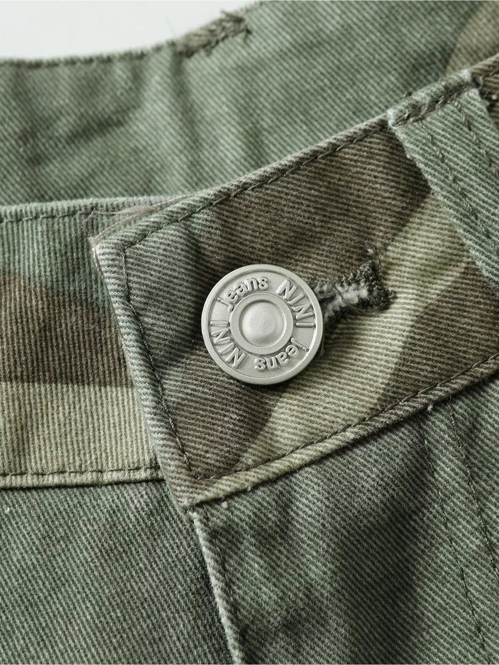 Relaxed fit camouflage cargo pants with a silver button closure detail.