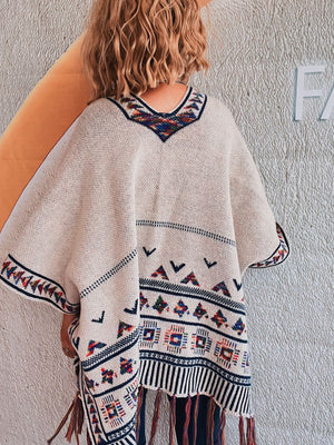 Apricot kimono with embroidered trim and fringe hem, featuring geometric patterns.