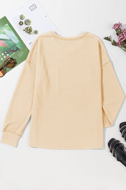 Tan ribbed knit long sleeve top with crew neck and relaxed fit.