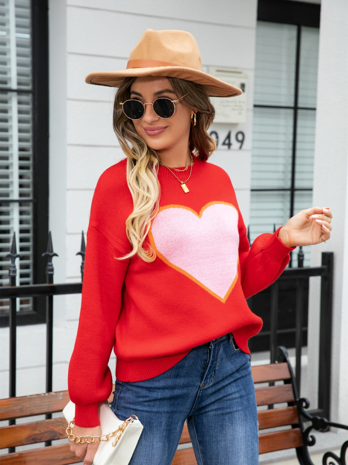 Red acrylic sweater with pink heart motif and balloon sleeves.