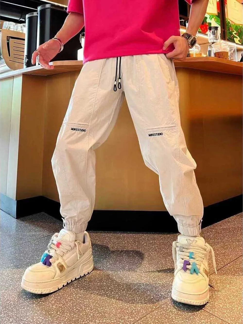 Off-white cotton joggers with zippered pockets and drawstring waist.