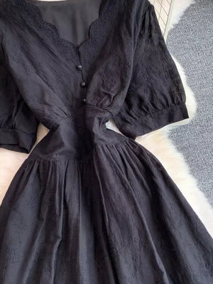 Black lace-embellished midi dress with V-neck, button front, and puff sleeves.