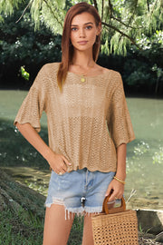 Khaki open-knit blouse with scalloped sleeves and a boat neck, styled with denim shorts.