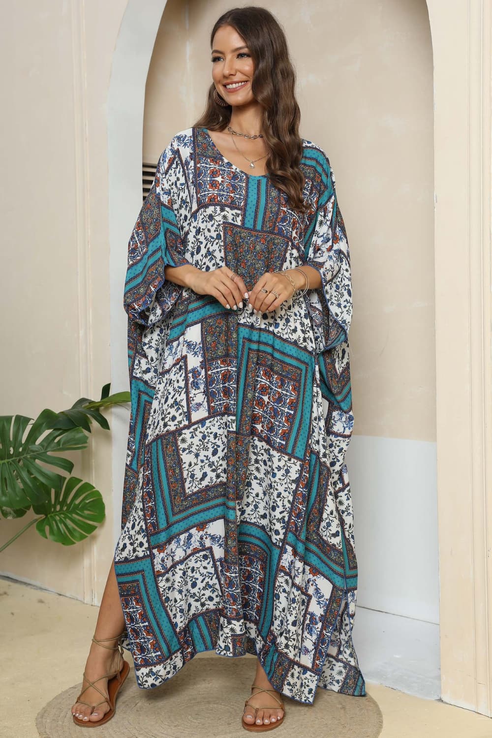 Patchwork caftan maxi dress in teal and red floral print with V-neck and wide sleeves.