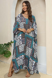 Patchwork caftan maxi dress in teal and red floral print with V-neck and wide sleeves.