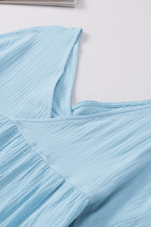 Pastel blue textured gauze blouse with gathered detail and square neckline.