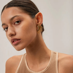 Gold sunburst crystal earrings with textured rays and sparkling accents.