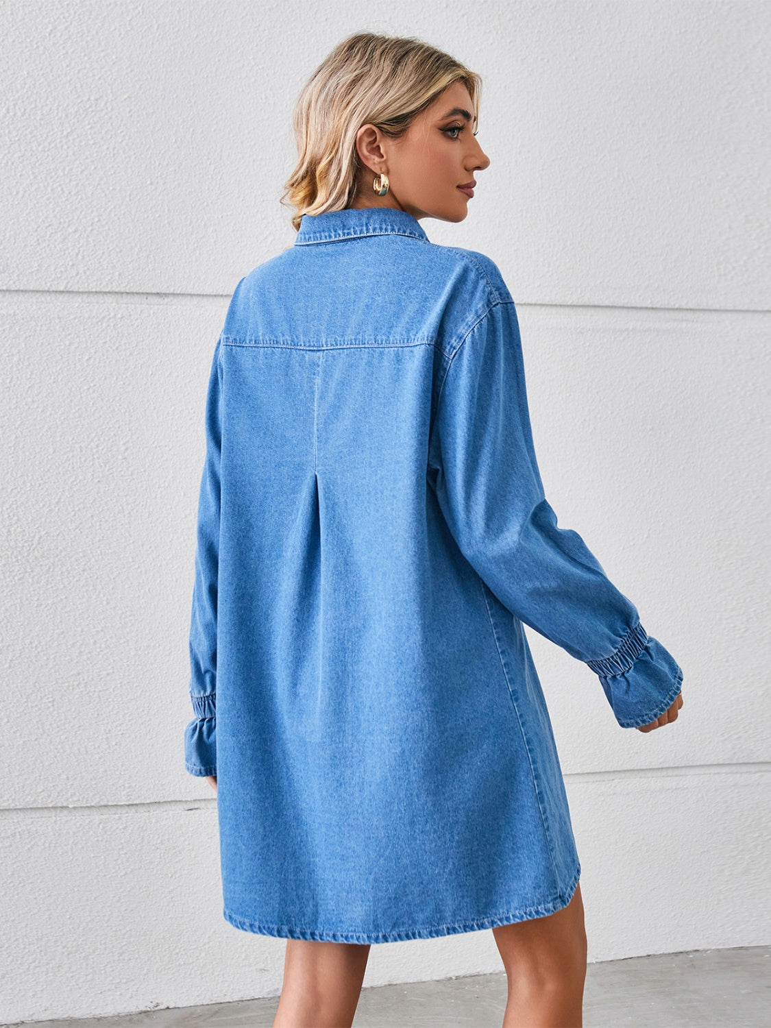 Denim shirt dress in dusty blue with oversized fit, button cuffs, and back pleat detail.