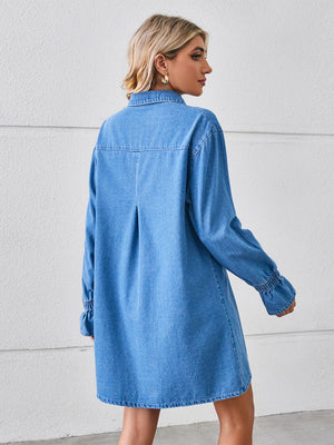 Denim shirt dress in dusty blue with oversized fit, button cuffs, and back pleat detail.