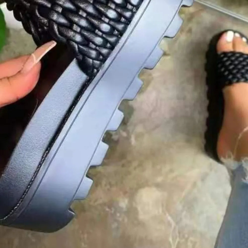 Black woven platform slide sandals with thick lug sole.