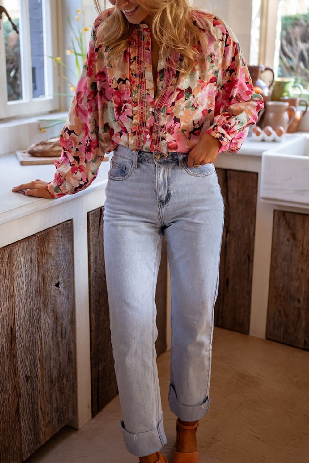 Pink floral print blouse with ruffle yoke and button front, worn with light wash jeans.