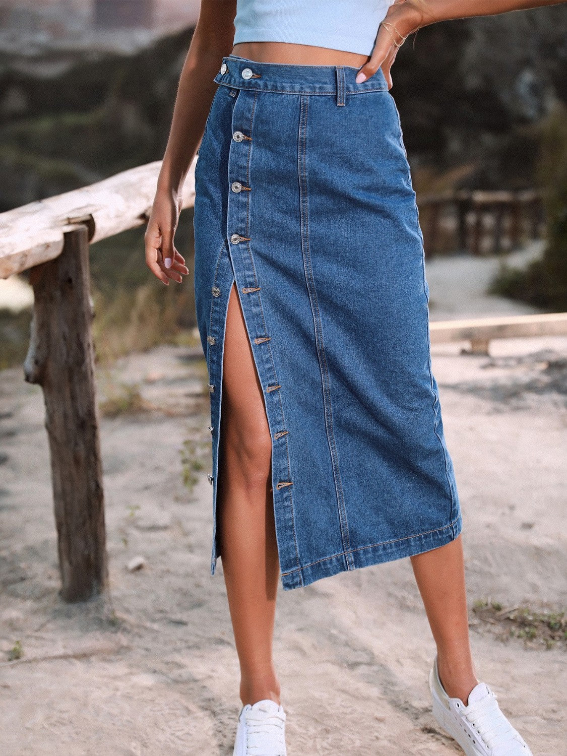 Button-front denim midi skirt in blue with a high slit and button detail.
