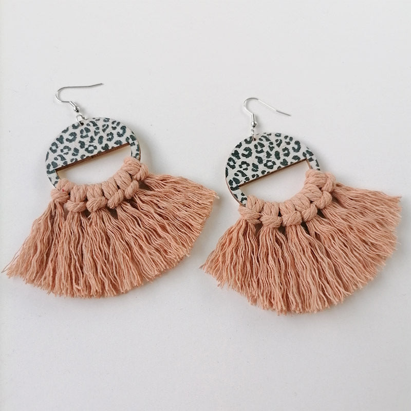 Leopard print tassel earrings with peach fringe and wooden half-circle detail.