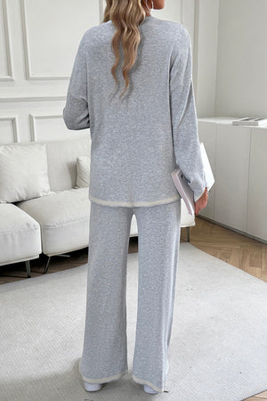 Light gray ribbed knit lounge set with cream trim, featuring a relaxed fit sweater and wide-leg pants.