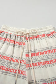 Ivory knit drawstring shorts with coral and grey abstract stripe pattern.