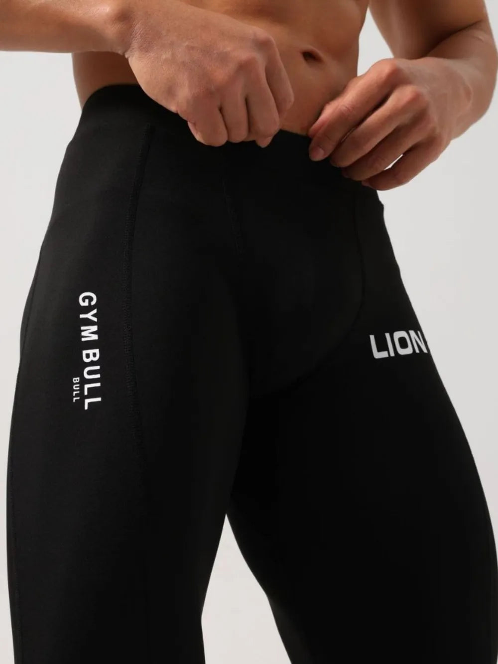 Black compression tights with white LION logo and GYM BULL text detail