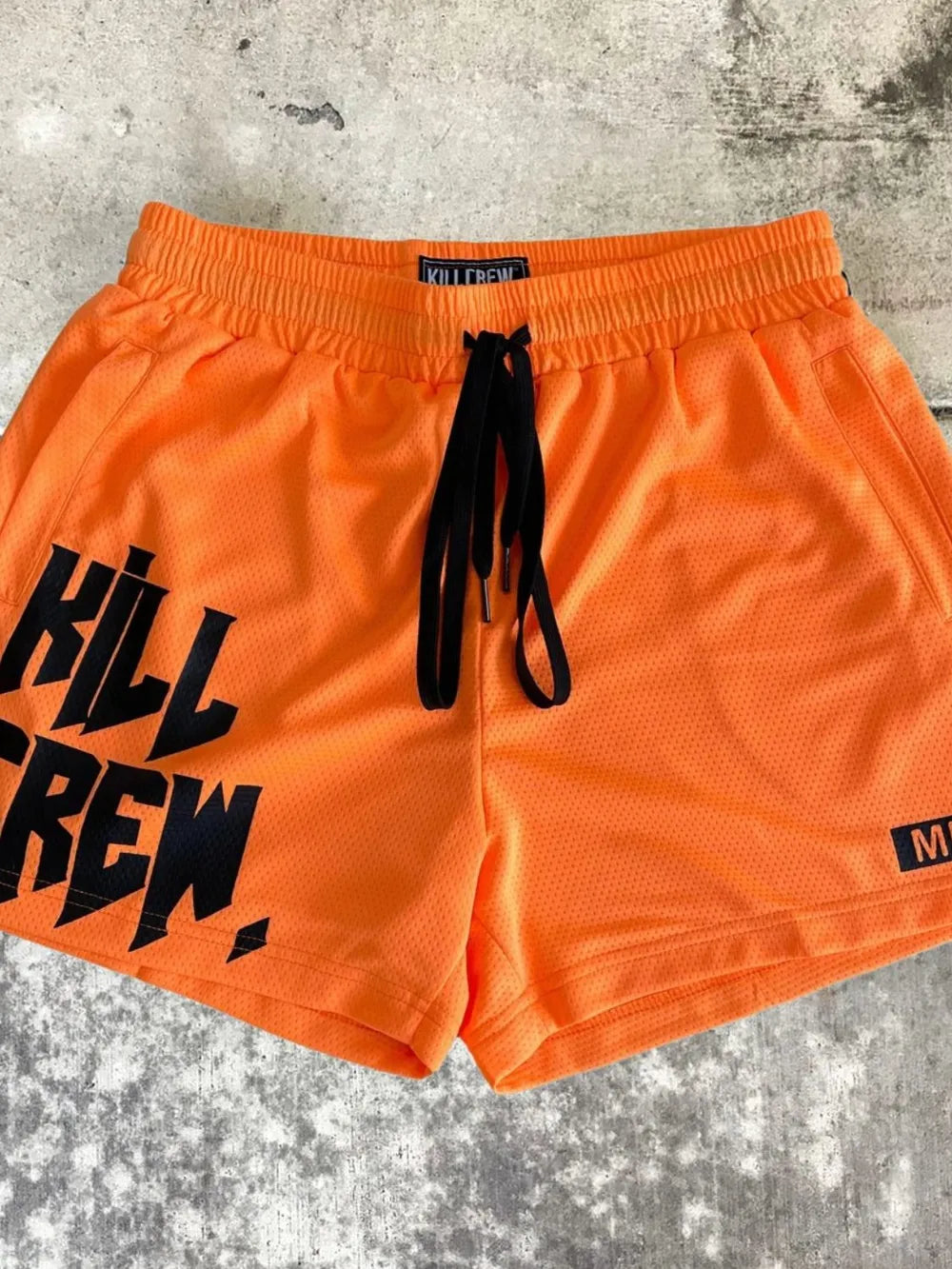 Orange mesh training shorts with black Kill Crew graphic and drawstring.