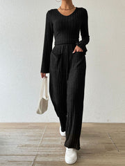 Black ribbed knit loungewear set with flared sleeves and wide-leg pants featuring patch pockets.